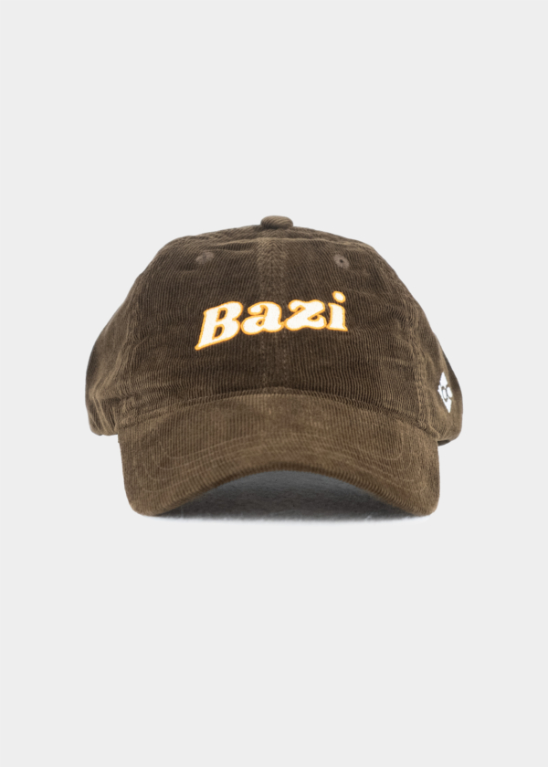 Frontansicht der braunen Cord-Cap mit gebogenem Schirm. Auf der Vorderseite ist der Schriftzug "Bazi" in weißer Schrift und orangener Umrandung gestickt, seitlich befindet sich ein kleines weißes Logo mit den Buchstaben "bc"